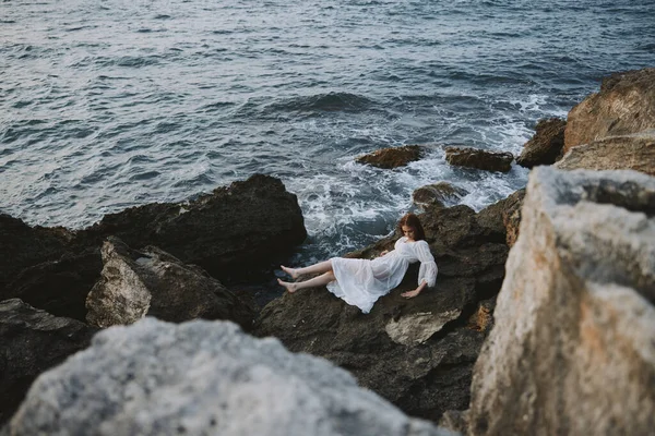 Frau liegt an felsiger Küste mit Rissen auf felsiger Oberfläche Blick von oben — Stockfoto