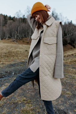 Sonbahar ormanındaki kadın temiz hava seyahati arazisinde yürüyor.