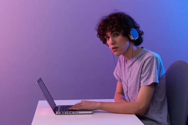 컴퓨터 앞에서 헤드폰을 끼고 비디오 게임을 하고 있는 곱슬머리의 사이버 공간의 남자 — 스톡 사진