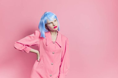 Mavi peruklu bir kadının portresi. Pembe elbise, kırmızı dudaklar, pembe arka plan.
