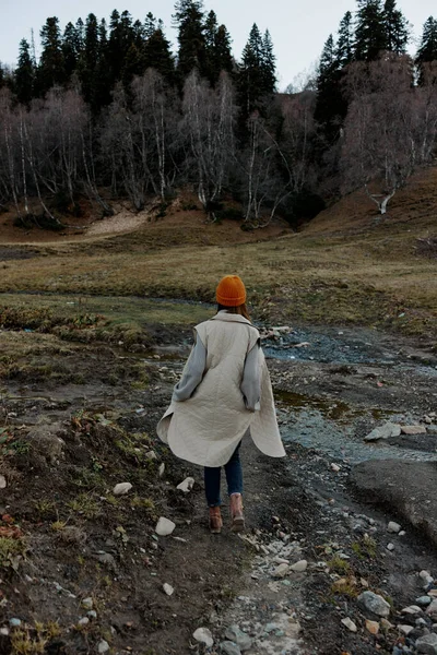 Touristin in Herbstkleidung über die Natur vor dem Hintergrund des Waldes — Stockfoto