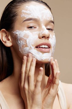 Esmer yüz maskesi kremi. Temiz yüz fırçası. Bej arka plan.