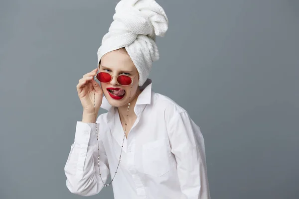 女性の赤いサングラスの化粧品とタオル頭の上灰色の背景 — ストック写真