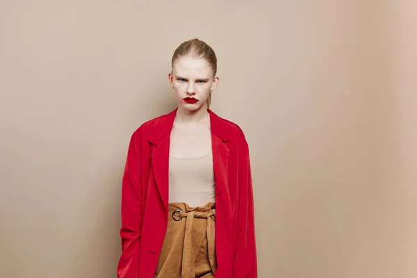 ファッショナブルな女性化粧で赤ジャケットベージュ背景 — ストック写真