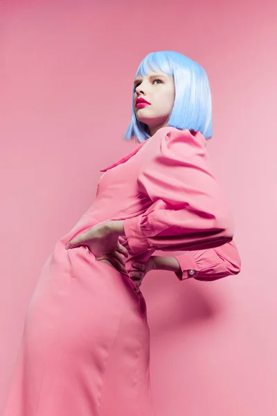 ファッショナブルな女性は青いウィッグメイクピンクの背景を身に着けている — ストック写真