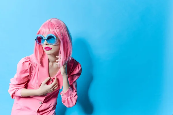 Bonita mujer en gafas azules lleva una peluca rosa modelo de estudio inalterado —  Fotos de Stock