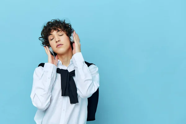 Auriculares hombre tecnología en una camisa blanca con suéter aislado fondos —  Fotos de Stock