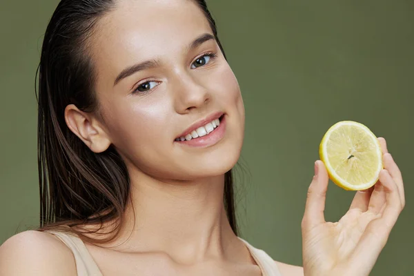 Wanita cantik lemon di tangan berpose kulit hijau bersih latar belakang — Stok Foto