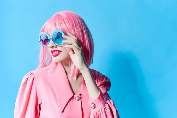 Mujer de moda en gafas azules lleva una peluca rosa fondo aislado — Foto de Stock