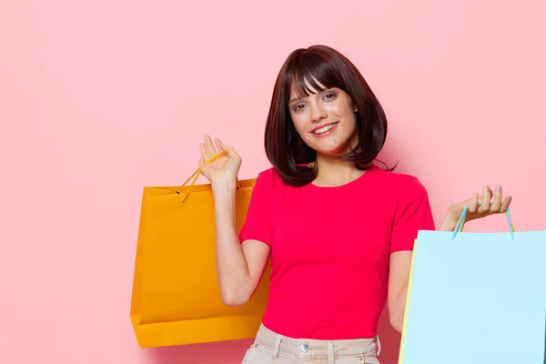 Vacker kvinna rosa t-shirts med shoppingväskor beskärd utsikt — Stockfoto