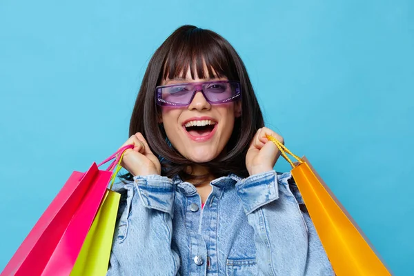 Mulher bonita em jaquetas jeans com sacos de compras coloridos Estilo de vida moda — Fotografia de Stock