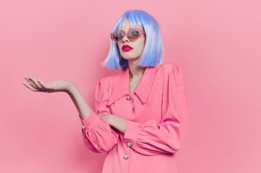 Güneş gözlüklü çekici kadın mavi peruklu makyaj stüdyo modeli giyiyor.