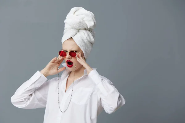 Mulher elegante óculos de sol vermelhos cosméticos com toalha na cabeça fundo cinza — Fotografia de Stock