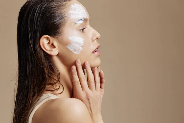 Mladá žena nanášení uklidňující obličejová maska kosmetické zblízka make-up — Stock fotografie