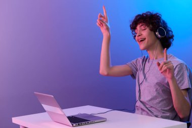 bir dizüstü bilgisayarın önünde kulaklıkla oynayan oyuncu siber alanı izole edilmiş arka plan