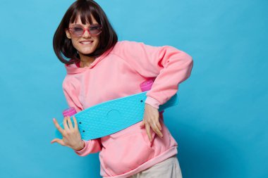 Pembe kazaklı genç kadın kaykay eğlencesi Yaşam tarzı moda