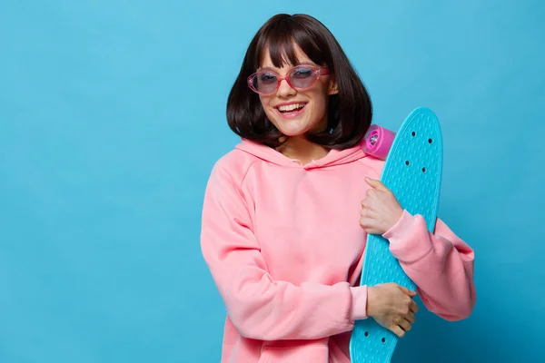 Ung kvinna i solglasögon med en skateboard livsstil mode — Stockfoto