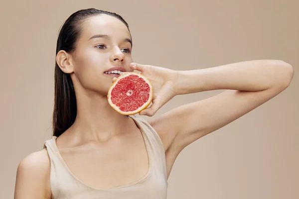 Портрет жінки грейпфрут біля обличчя чистий догляд за шкірою здоров'я ізольований фон — стокове фото