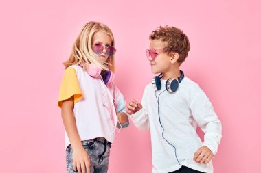 Şirin, gülümseyen çocuklar, pembe arka plan çalan kulaklıklar.