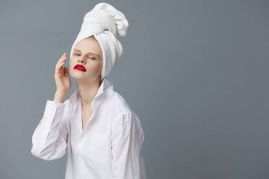 Kafasında havluyla beyaz gömlekli güzel bir kadın. Stüdyo modeli değiştirilmemiş.