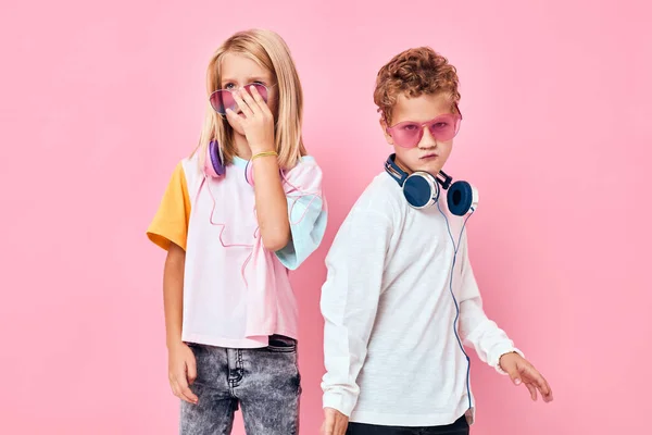 Glada par barn i solglasögon ha kul med vänner studio poserar — Stockfoto