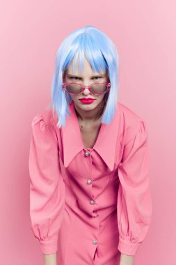 Mavi peruklu çekici kadın. Pembe elbiseli, kırmızı dudaklı stüdyo modeli.