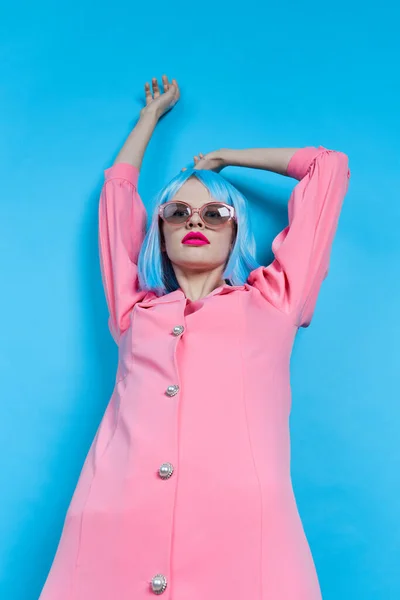 Mujer de moda en gafas de sol lleva una peluca azul maquillaje fondo azul — Foto de Stock
