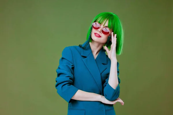 Γυναίκα σε πράσινο περούκα μοντέρνα γυαλιά μόδας ποζάροντας πράσινο φόντο — Φωτογραφία Αρχείου
