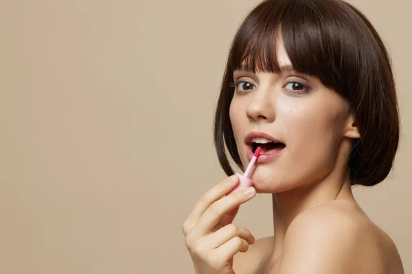 Junge Frau Make-up Lipgloss nahe dem Gesicht nackte Schultern Nahaufnahme Lifestyle — Stockfoto