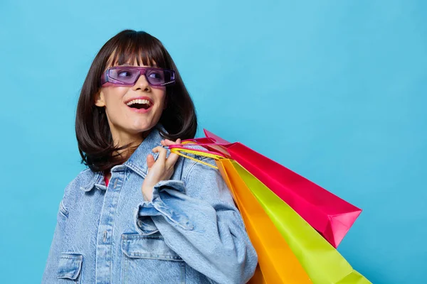 Mulher bonita em jaquetas jeans com sacos de compras coloridos vista cortada — Fotografia de Stock