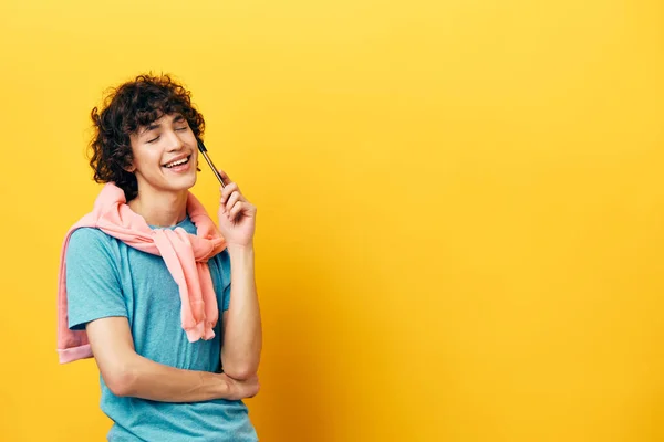 Chico rizado en una camiseta azul idea chaqueta rosa fondo amarillo —  Fotos de Stock