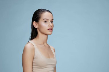 Portre kadını cilt bakımına dokunur. Stüdyoya yakın çekim yaşam tarzı pozu verir.