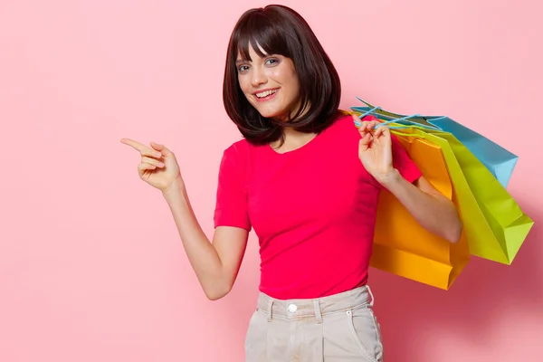 Νεαρή γυναίκα με πολύχρωμες τσάντες ψώνια απομονωμένη φόντο — Φωτογραφία Αρχείου