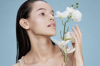 Orkide kadın portresi. Çekici bir yüz ve izole bir arka plan.