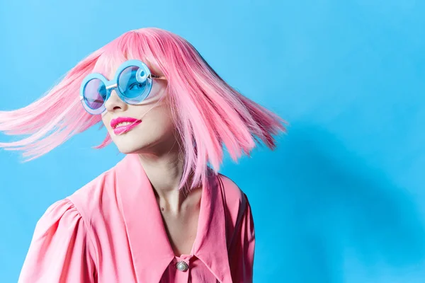 Λαμπερή γυναίκα με μπλε γυαλιά φοράει ροζ περούκα μοντέλο στούντιο αναλλοίωτο — Φωτογραφία Αρχείου