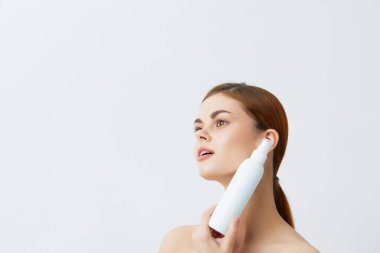 Çıplak omuzlu güzel kadın cilt bakım losyonu.