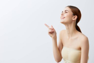 Güzel bir kadın, kızıl saçlı, çıplak omuzlu, kozmetik ciltli, izole bir arka plan.