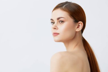 Güzel bir kadın, gülümseyen bir kadın. Çıplak omuzlar. Temiz cilt cazibesi.