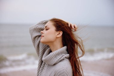 Okyanus turizminde uçan kazak giyen neşeli kadın. Rahatlayan mutlu kadın.