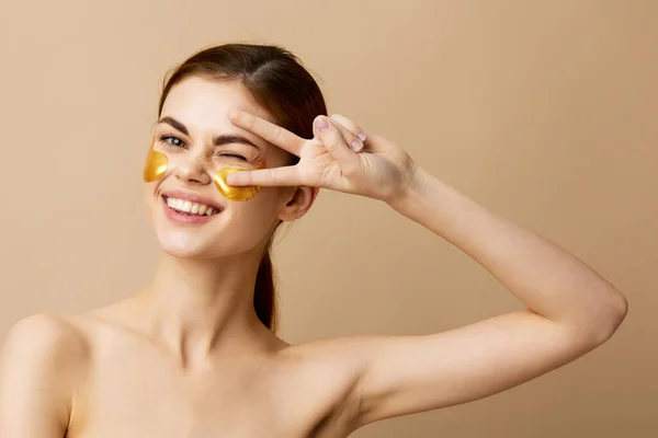 Wanita muda tambalan emas kulit bersih senyum berpose latar belakang terisolasi — Stok Foto