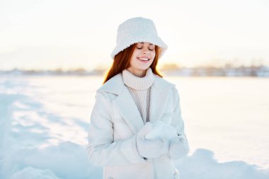 Kışın giyinmiş kadın karda yürüyor. 