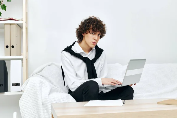 Man op een witte bank in de voorkant van een laptop leren Lifestyle technologie — Stockfoto