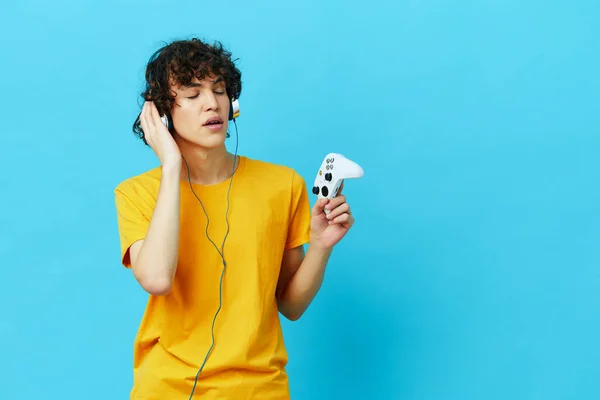 Gamer juega con joystick en camisetas amarillas fondos aislados — Foto de Stock