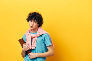 Kitap okuyan bir adam pembe ceketi sarı arka planda öğreniyor.