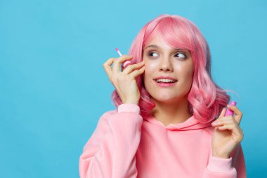 Pembe peruklu dudak parlatıcısı olan genç bir kadın.