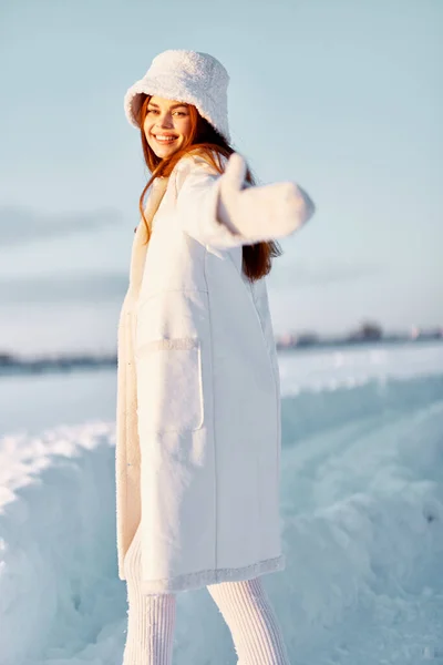 Jonge vrouw in een witte jas in een hoed winter landschap wandeling natuur — Stockfoto