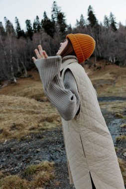 Doğa üzerinde turuncu şapkalı bir kadının portresi