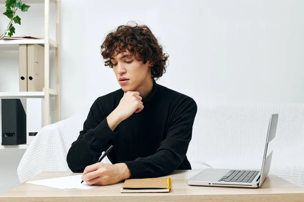 Krullende jongen op een witte bank in de voorkant van een laptop leren Lifestyle technologie — Stockfoto