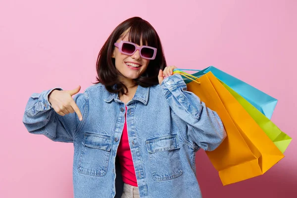 Młoda kobieta z kolorowymi torbami na zakupy odizolowane tło — Zdjęcie stockowe