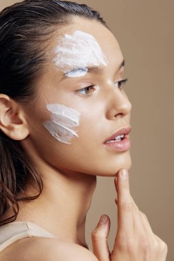 Portre kadın eli, yüz kreminin yanında gençleştirme büyüsü, yakın çekim.